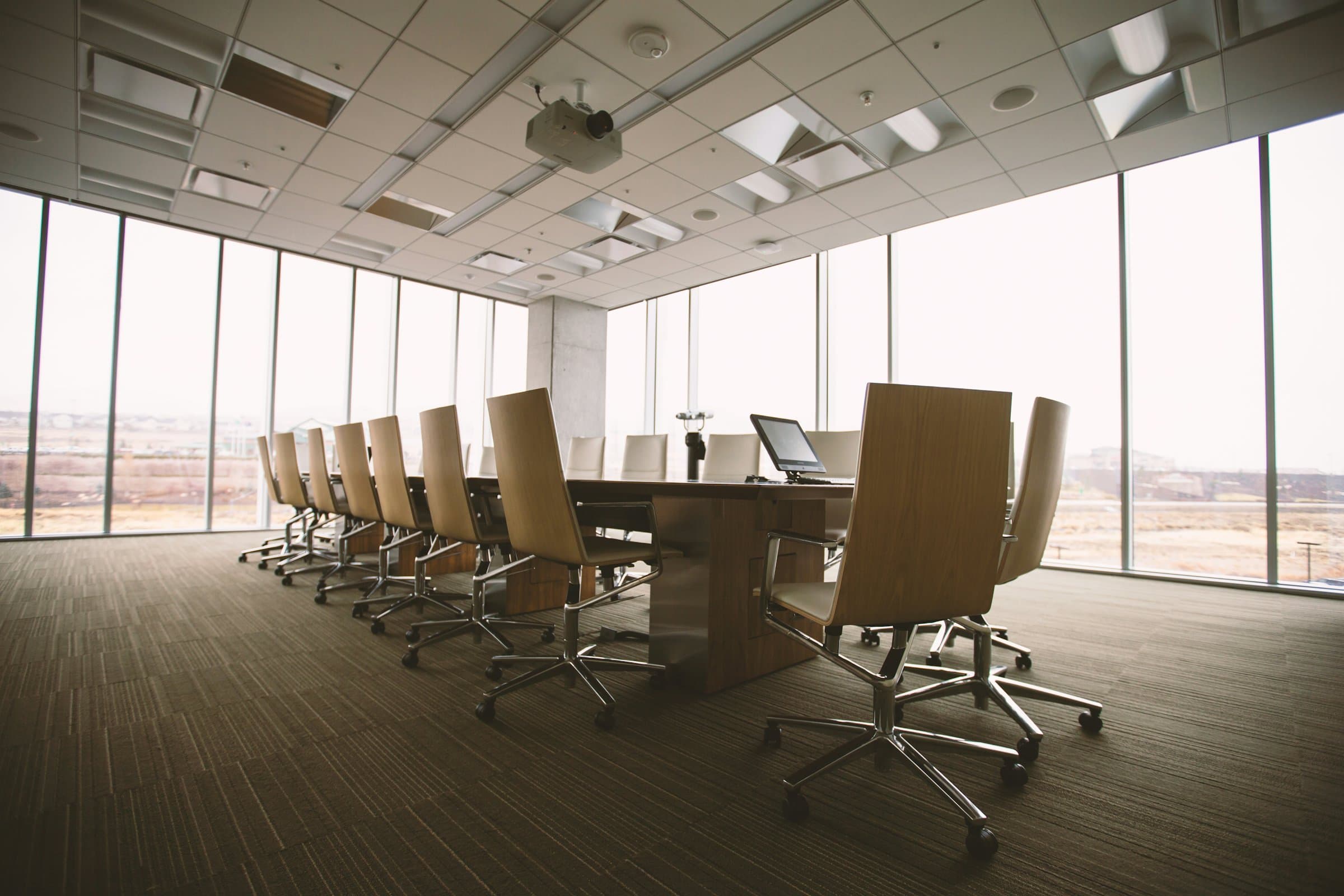 Empty law firm boardroom with a long table and floor-to-ceiling windows